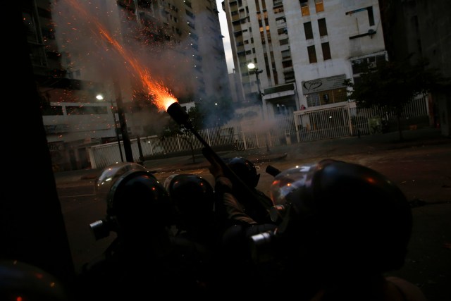 Police fire teargas at anti-government protesters during clashes in Caracas