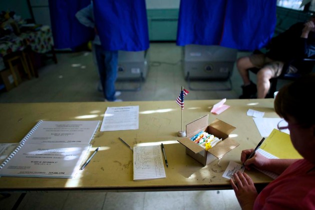 Un control oficial una de casilla, mientras que otro papeleo se completa en el día de las elecciones primarias en Guerin Recreation Center en Filadelfia / Marcos Makela / Reuters