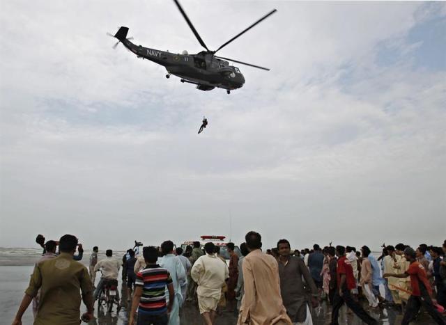  Un helicóptero de la Fuerza Armada paquistaní participa en las labores de rescate de los cadáveres de las víctimas que se ahogaron en la playa de Karachi. Foto EFE