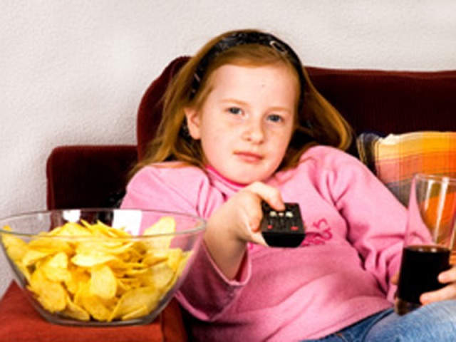 niña viendo tv y comiendo chucherías