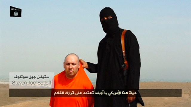 Still image from undated video of a masked Islamic State militant speaking next to man purported to be U.S. journalist Steven Sotloff at an unknown location