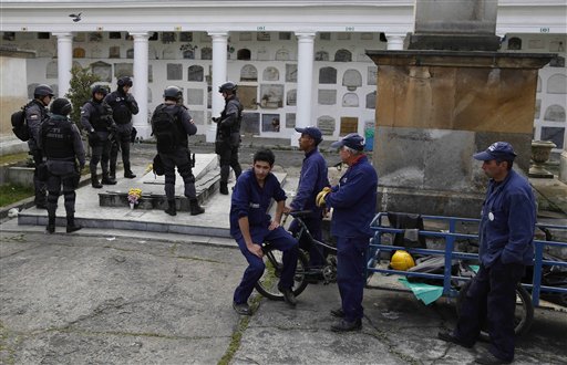 Agentes de policía custodian la tumba del exguerrillero y candidato presidencial Carlos Pizarro en el cementerio central de Bogotá, el miércoles 26 de noviembre de 2014. La Fiscalía General ordenó el miércoles la exhumación de los restos óseos de Pizarro para establecer la posible participación de agentes del Estado en su asesinato, perpetrado en 1990. (AP foto/ Fernando Vergara)