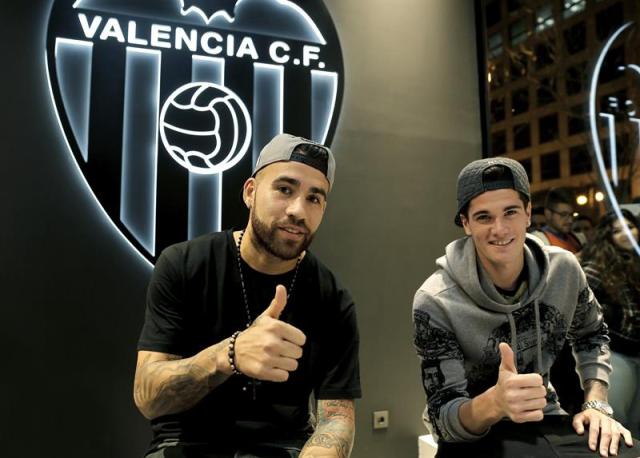 Los jugadores argentinos del Valencia CF, Nicolás Otamendi (i) y Rodrigo de Paul (d), tras las declaraciones que han efectuado ante los medios de comunicación en la tienda del club, en el centro de la ciudad, donde más de medio millar de aficionados esperaban conseguir un autógrafo de sus ídolos. EFE/Juan Carlos Cárdenas