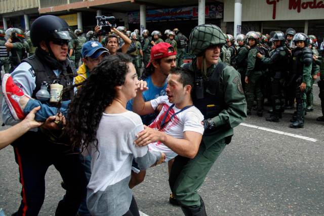 An opposition students is carry away after being injured during against President Nicolas Maduro's government in San Cristobal