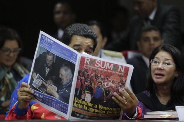 Nicolás Maduro lee un periódico durante la cumbre de Panamá en compañía de su mujer, Cilia Flores. / AFP