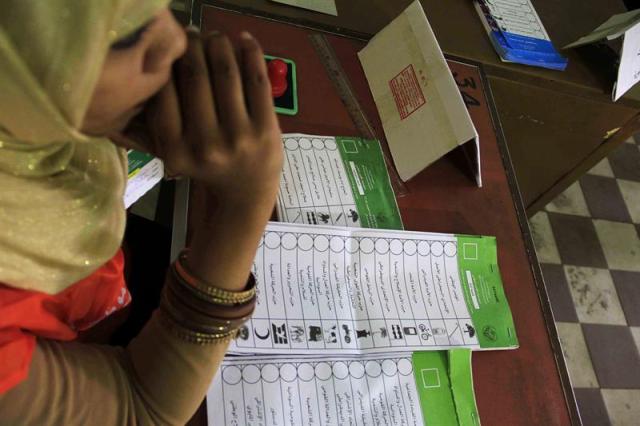 Una mujer encargada de recoger votos para las elecciones presidenciales y legislativas espera la llegada de votantes en el colegio Saint Francis de Jartum, Sudán, hoy, 13 de abril de 2015. Los comicios presidenciales y legislativos arrancaron hoy en Sudán con el presidente del país, Omar Hasan al Bachir, como favorito indiscutible a la jefatura de Estado y en medio del boicot de los principales partidos de la oposición. Hoy tiene lugar la primera de las tres jornadas que durará la votación, en la que están llamados a las urnas 13,3 millones de electores en los 18 estados del país. EFE/MARWAN ALI