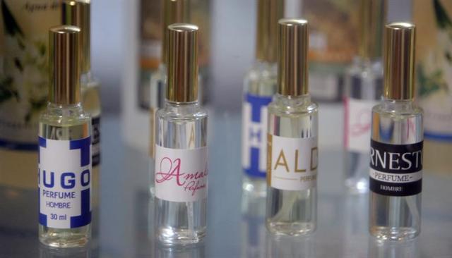 Los perfumes ?Hugo", "Ernesto", ?Alba" y "Amalia? son exhibidos en una vidriera este jueves, 25 de septiembre de 2014, durante el Congreso Labiofam 2014, en La Habana (Cuba). Cuba acaba de lanzar dos perfumes creados por sus expertos en cosmetología para recordar al legendario guerrillero "Che" Guevara y al fallecido presidente venezolano Hugo Chávez: "Ernesto" y "Hugo" son los nombres de esas fragancias. EFE/Ernesto Mastrascusa