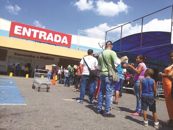 Valencianos se rebuscan en las colas de los supermercados