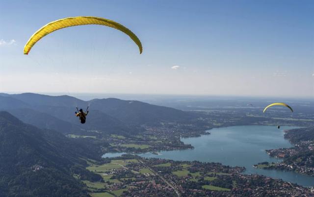 Varias personas disfrutan del parapente sobre el lago Tegernsee en Rottach-Egern al sur de Bavarlia ayer, lunes 3 de agosto de 2015. EFE/Matthias Balk