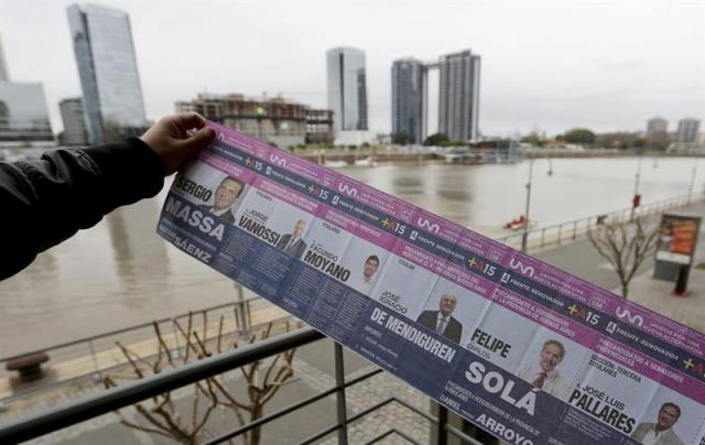  Un hombre muestra una papeleta electoral de las primarias argentinas hoy, miércoles 5 de agosto de 2015, en Buenos Aires.Papeletas de más de un metro y listas interminables en las que figuran personajes variopintos, incluidos espías, son algunas de las curiosidades de las primarias que se celebrarán el domingo en Argentina. Unos 32 millones de argentinos están convocados a votar en estas elecciones, en las que se definirán los aspirantes a la Casa Rosada y miles de cargos menores, y que en la práctica constituyen un ensayo de las generales del próximo octubre. EFE/David Fernández