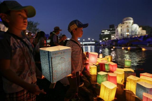 Un niño ilumina una linterna junto al río Motoyasu en memoria de las víctimas de la bomba atómica en el Parque de la Paz de Hiroshima (Japón) hoy 6 de agosto de 2015. La bomba lanzada por un avión estadounidense sobre la ciudad nipona acabó de forma inmediata con la vida de unas 80.000 personas, aunque este número aumentaría hacia finales de 1945, cuando el balance de muertos se elevaba a unos 140.000, y en los años posteriores las víctimas por la radiación sumaron muchas más. EFE/Kimimasa Mayama