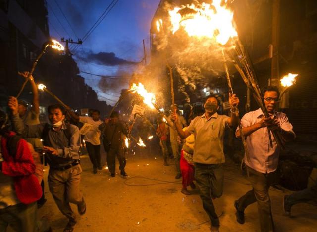 Varias personas de la comunidad tharu se manifiestan con antorchas en contra de la nueva división federal propuesta para la Constitución nepalesa en Katmandú, Nepal, hoy 11 de agosto de 2015. Los principales partidos políticos nepalíes acordaron el pasado fin de semana que la Constitución del Nepal que se espera aprobar el domingo divida al país el seis provincias o estados federados, en los que Surkhet, a unos 600 kilómetros de Katmandú, quedaría dentro de una región distinta a la que se encuentra en la actualidad. EFE/Narendra Shrestha