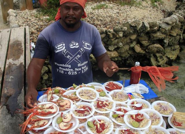 Fotografía del 7 de agosto de 2015de un hombre vendiendo indebidamente pequeñas langostas que no cumplen con los estandares de comercialización a los visitantes del Parque Nacional Natural Los Corales del Rosario y de San Bernardo, al norte de Colombia. Nativos del norte de Colombia se unieron a las autoridades ambientales para ayudar a conservar el valioso conjunto de biodiversidad marina y terrestre de un parque de 120.000 hectáreas, actividad que además les permite asegurar su propio sustento. La iniciativa es una suma de esfuerzos del Parque Nacional Natural Los Corales del Rosario y San Bernardo, en el Caribe colombiano, y de pescadores de la región para la conservación de las especies. EFE/RICARDO MALDONADO ROZO