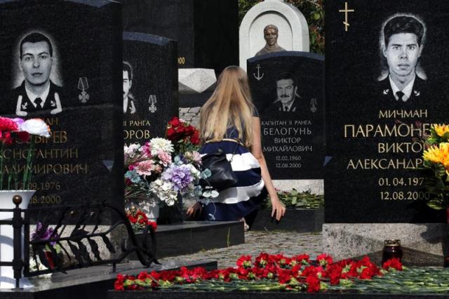 Una familiar del capitán Victor Belogun deposita flores en su tumba durante la ceremonia de conmemoración del decimoquinto aniversario del naufragio del submarino nuclear "Kursk" en San Petersburgo, Rusia, hoy 12 de agosto de 2015. El "Kursk" participaba en unos ejercicios navales en el mar de Barents cuando se produjo la explosión en el compartimento de torpedos que destruyó la proa del submarino y causó el hundimiento del buque, dejando 118 víctimas, las mismas que formaban la tripulación del submarino. EFE/Anatoly Maltsev