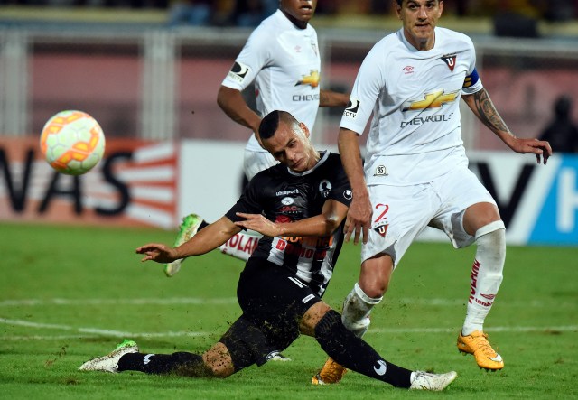 Johan Moreno (L) of Venezuela's Zamora, vies for ball with Norberto Araujo of Ecuador's Liga de Quito, during their Copa Sudamericana 2015 football match held at the Carolina stadium, in Barinas, Venezuela, on August 13, 2015. AFP PHOTO/JUAN BARRETO