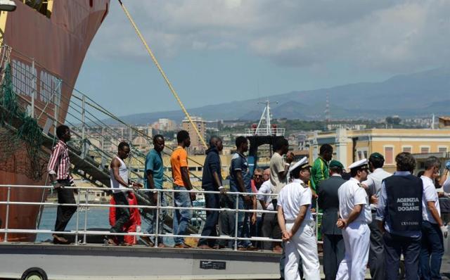 Los inmigrantes desembarcan del buque noruego Siem Pilot llega al puerto de Catania, Sicilia (Italia) hoy, 17 de agosto de 2015. Los 312 inmigrantes salvados y los 49 cadáveres recuperados el sábado en una embarcación frente a Libia fueron desembarcados hoy en el puerto de Catania en una jornada en la que también llegaron a Italia otras 457 personas socorridas en los últimos días. EFE/Orietta Scardino