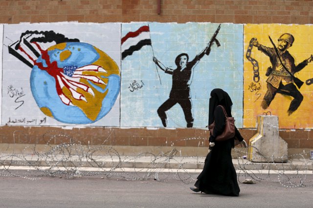 Foto: Una mujer camina pasado el graffiti pintado por activistas pro-Houthi en la pared de la embajada saudí en la capital de Yemen, Sanaa 18 de agosto de 2015. Una guerra civil en Yemen estalló a finales de marzo, cuando los huzíes Irán-aliados, que habían apoderado de la capital Saná última septiembre, condujo hacia el sur, lo que obligó al gobierno a huir al exilio en Arabia Saudita y que provocó una intervención militar del Golfo. REUTERS