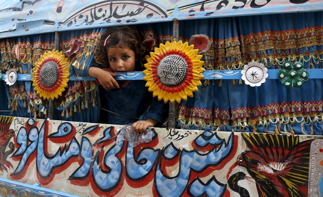 Foto: Una niña mira por la ventana de una camioneta que se utiliza como taxi en Peshawar, Pakistán 18 de agosto de 2015. / REUTERS