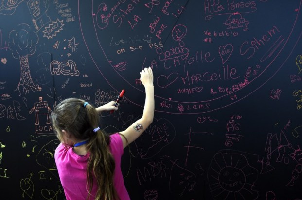 Foto: A girl has draws on a chalkboard on the Champ de Mars in Paris on August 19, 2015 during the 'Journee mondiale des oublies des vacances' (International day for children who didn't go on vacation) organised by the Secours Populaire French association. AFP 