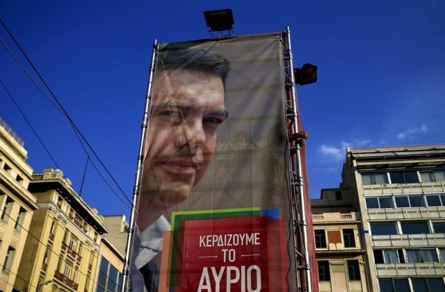 A worker hangs a banner with an image of former Greek prime minister and leader of leftist Syriza party Alexis Tsipras at the party's pre-election kiosk in Athens, Greece, in this September 4, 2015 file photo. The banner reads "We are winning tomorrow". A general election will take place in Greece this week. REUTERS/Alkis Konstantinidis/FilesGLOBAL BUSINESS WEEK AHEAD PACKAGE - SEARCH 'BUSINESS WEEK AHEAD SEPTEMBER 14' FOR ALL 27 IMAGES