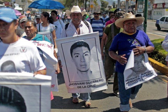 A relative (C) of Mexican missing student Jhosivani Guerrero de la Cruz holds his portrait during a march in Acapulco, Guerrero State, Mexico, on March 4, 2015. Jhosivani Guerrero is the second of the 43 missing students of Ayotzinapa whose remains are identified, the Mexican government informed on September 16, 2015.  AFP PHOTO / Pedro PARDO