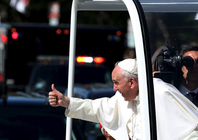 Pope Francis gives a thumbs up to the crowd as he rides down Constitution Avenue in his Popemobile in Washington on day two of his first visit to the United States in Washington September 23, 2015. Pope Francis met with U.S. President Obama earlier this morning. REUTERS/Gary Cameron