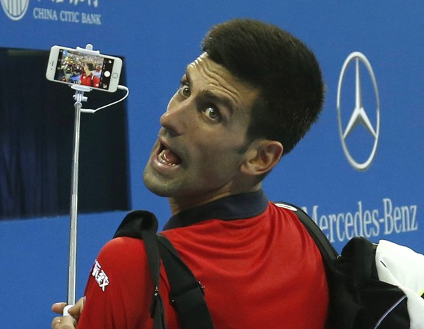 Novak Djokovic de Serbia tiene un selfie con el teléfono móvil de un fan después de ganar contra Simone Bolelli de Italia en singles de sus hombres que coincida en el torneo de tenis Abierto de China en Beijing, China, 06 de octubre de 2015. REUTERS