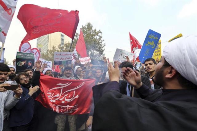 Manifestantes iraníes sostienen pancartas y ondean banderas durante una protesta con motivo del 36 aniversario de la toma de la embajada estadounidense en la capital iraní en 1979, ante la embajada de Estados Unidos en Teherán, Irán, hoy, 4 de noviembre de 2015. Los cánticos de "Muerte a América" y "Muerte a Israel" volvieron a resonar con fuerza frente a la legación diplomática estadounidense, hoy convertida en un centro cultural y museo, en una ceremonia destinada a recordar todos los agravios sufridos por Irán a manos de los EEUU y sus aliados occidentales. Todos los actos, discursos y actividades como la ritual quema de banderas de EEUU, Israel y el Reino Unido también sirvieron para demostrar que pese al deshielo entre Irán y la comunidad internacional al calor del acuerdo sobre su programa nuclear, aún queda mucho para aproximar posturas entre la República Islámica y Occidente. EFE/STR