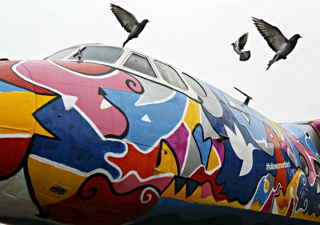 Las palomas vuelan por una pintada Antonov-24 avión en el aeropuerto Zhulyany en Kiev, Ucrania, 05 de noviembre de 2015. El avión de 45 años de edad, se ha convertido en un espacio de arte y exposición de las autoridades del aeropuerto con la ayuda del artista georgiano Avtandil Gurgenidze . REUTERS / Gleb Garanich