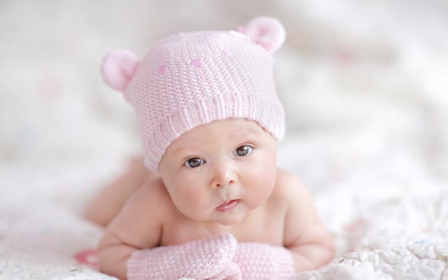 newborn baby girl in pink knitted bear hat