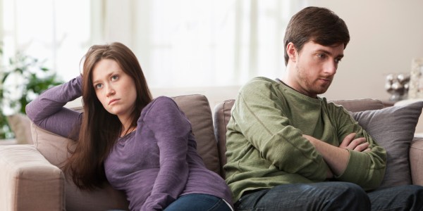 Caucasian couple arguing on sofa