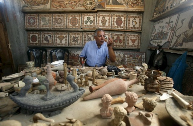 Arqueología Nafez Abed se sienta delante de esculturas y mosaicos intrincados en su taller, en el campamento de refugiados de Shati en la ciudad de Gaza, 08 de noviembre, taller de bricolaje estrecho de 2015. Nafez Abed está lleno de esculturas y mosaicos intrincados decorados con los patrones de la bizantina, griega y romana . Es un emporio de la antigüedad de Oriente Medio escondido en Gaza. Y nada de esto es real. Fotografía tomada 8 de noviembre de 2015. Para que coincida historia PALESTINOS-ARQUEOLOGÍA REUTERS / Suhaib Salem