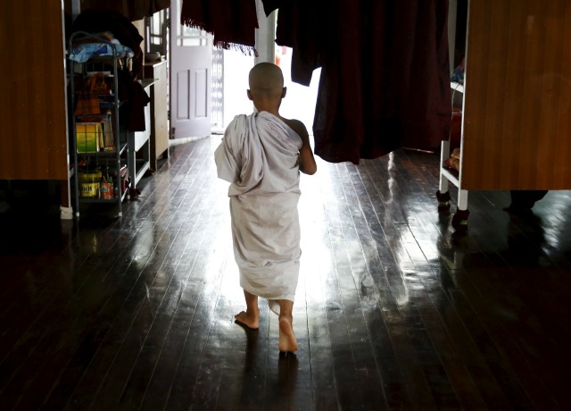 Monje prenovicio Zarnayar, 11 años de edad, camina como él estudia textos budistas en un monasterio fuera de Mandalay, Myanmar, 10 de noviembre de 2015. REUTERS / Olivia Harris