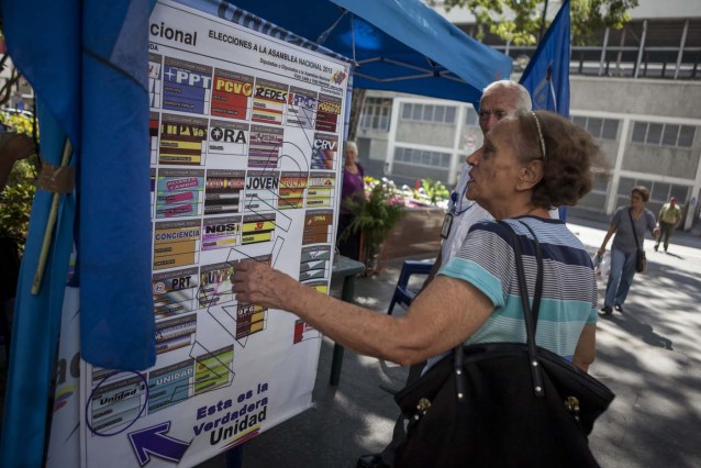 CAR14. CARACAS (VENEZUELA) 02/12/2015. Fotografía del 28 de noviembre del 2015 de un puesto informativo de la oposición en el centro de la ciudad de Caracas (Venezuela). Las elecciones de la Asamblea Nacional (AN) venezolana del próximo domingo pueden poner sobre la mesa diferentes escenarios, algunos de los cuales podrían cambiar la dinámica política del país caribeño tal como se conoce en los últimos 15 años. En manos de quienes obtengan la mayoría del Parlamento unicameral, de 167 escaños, recaerá el poder con el que se podría amenazar o consolidar la llamada revolución bolivariana, el proyecto político ideado por el fallecido Hugo Chávez, y liderado ahora por su hijo político, el presidente venezolano, Nicolás Maduro. EFE/MIGUEL GUTIERREZ