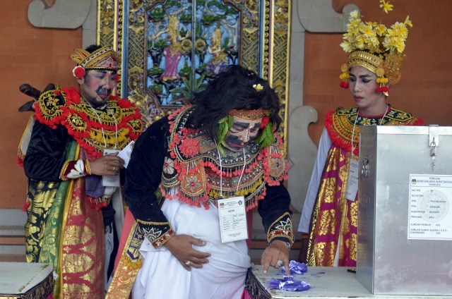 Los miembros de mesa vestidos de artistas tradicionales balineses votar en Badung regencia en la isla indonesia de Bali 09 de diciembre 2015 en esta foto tomada por Antara Foto. Se esperaba que alrededor de 100 millones de indonesios que ir a las urnas el miércoles en muchas partes del país para elegir a los jefes de gobierno local. REUTERS / Wira Suryantala / Antara