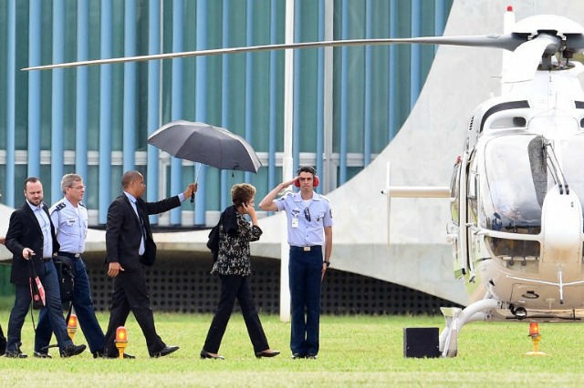 Tableros presidente de Brasil, Dilma Rousseff (tercera L) un helicóptero en el Palacio de Alvorada en Brasilia para viajar a Boa Vista, en el norte del Estado de Roraima en Brasil el 9 de diciembre de 2015 para asistir a una ceremonia de entrega de viviendas sociales. Asediado presidente Dilma Rousseff de Brasil el 8 de diciembre ganó un respiro en su batalla para evitar el juicio político cuando la Corte Suprema ordenó la comisión teniendo en cuenta su caso suspendido por una semana. AFP PHOTO / EVARISTO SA