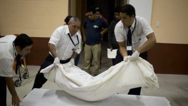 tres personas transportan un cadáver en una imagen de archivo