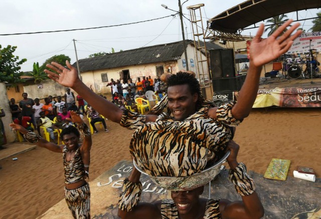 Contorsionistas de Costa de Marfil se realizan durante el festival de artes de calle Grand Bassam en Grand-Bassam el 13 de diciembre de 2015.