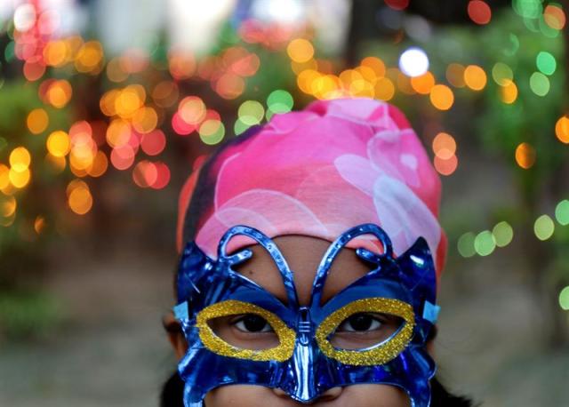 Una niña india lleva una máscara con motivo de la celebración de las fiestas navideñas en Calcuta, India, hoy, 21 de diciembre de 2015. EFE/PIYAL ADHIKARY