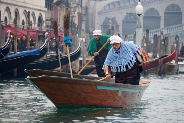 Gondoleros vestidos como "Befanas" participan en una carrera de góndolas en el gran Canal con motivo de la celebración de la fiesta de la Befana, en Venecia (Italia), hoy, 6 de enero de 2016. Cuenta la leyenda que los Reyes Magos, en su camino hacia Belén para llevar las ofrendas al niño Jesús, se encontraron con una anciana a la que pidieron información e incluso compañía para llegar al portal. Ella se negó a acompañarles y Melchor, Gaspar y Baltasar tuvieron que proseguir su camino solos. Pero arrepentida, la Befana hizo acopio de dulces y salió al encuentro de los Magos de Oriente. En su camino fue preguntando casa por casa por los tres Reyes y dejando a los niños de cada hogar parte de los caramelos que llevaba consigo. EFE/Andrea Merola