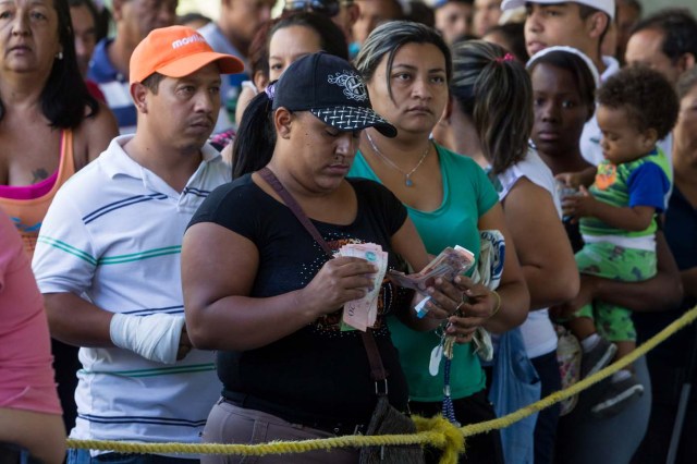 CAR01. CARACAS (VENEZUELA), 23/01/2016.- Una mujer cuenta dinero mientras hace fila para comprar una bolsa con alimentos en una venta realizada en un edificio del plan habitacional gubernamental "Misión Vivienda" hoy, sábado 23 de enero de 2016, en la ciudad de Caracas (Venezuela). El presidente del Parlamento venezolano, el opositor Henry Ramos Allup, reiteró hoy que los problemas que afronta su país con una aguda crisis económica de carestía y escasez se agravarán si Nicolás Maduro sigue en la jefatura del Estado. La situación económica del quinto productor de petróleo del mundo se ha visto golpeada por la caída de los precios del crudo, que inició en septiembre de 2014 cuando se cotizaba en 90 dólares por barril y que cerró esta semana en 21,63 dólares. "Este Gobierno va a resolver nada; mientras esté allí todos los problemas de Venezuela van a empeorar totalmente. Hasta que no salgamos democráticamente de este Gobierno, Venezuela no se va a recuperar ni podrá resolver ninguno de sus problemas", subrayó en un discurso ante manifestantes antigubernamentales en Caracas. EFE/MIGUEL GUTIERREZ