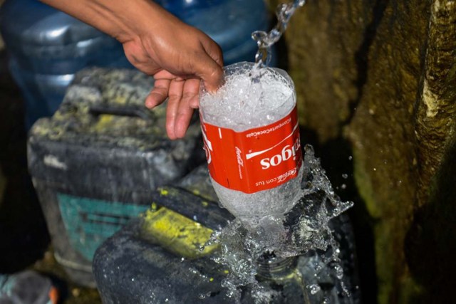 A man fills a jerry can with water from the Wuaraira Repano mountain in Caracas on January 21, 2016. Venezuela suffers a severe water shortage, which the government attributes to the delay in the arrival of the rainy season for the third consecutive year due to El Nino weather phenomenon. AFP PHOTO/FEDERICO PARRA / AFP / FEDERICO PARRA