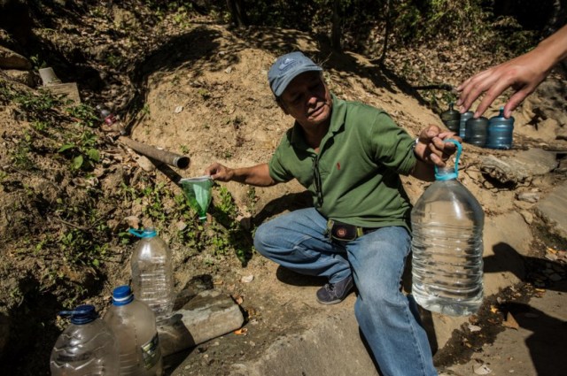 Jesús Pinto llena garrafones de agua cerca del cerro Ávila en Caracas. Este año El Niño ha causado sequía, por lo que miles de venezolanos buscan maneras alternativas de conseguir agua.  FOTO: Meridith Kohut para The New York Times