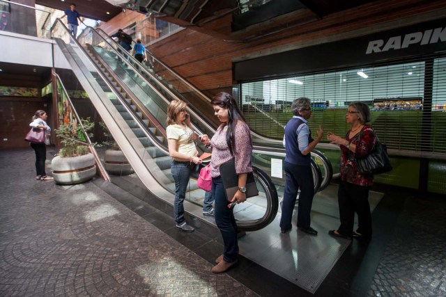 CAR04. CARACAS (VENEZUELA), 10/02/2016.- Clientes de un centro comercial suben por las escaleras eléctricas, apagadas por el racionamiento, hoy, miércoles 10 de febrero de 2016, en Caracas (Venezuela). Los centros comerciales de Venezuela iniciaron hoy sus actividades con un horario restringido que los lleva a trabajar durante un promedio de cuatro horas diarias, una situación que elevó las alarmas de las organizaciones relacionadas con el sector que auguran pérdidas de dinero y empleos. EFE/Miguel Gutiérrez