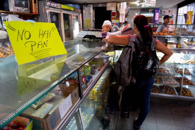 TO GO WITH AFP STORY by Valentina Oropeza and Ernesto Tovar A woman waits at a bakery displaying a sign reading "No Bread", in Caracas on February 25, 2016. On any given day, people in Venezuela can wait hours to get some subsidized milk, cooking oil, milk or flour -- if they can find any -- with some bakeries rationing their bread production and others selling no bread at all. Venezuela, which is sitting on the biggest known oil reserves from which it derives 96 percent of its foreign revenues, has been devastated by the drop in prices and is beset with record shortages of basic goods, runaway inflation and an escalating economic crisis.    AFP PHOTO / FEDERICO PARRA / AFP / FEDERICO PARRA