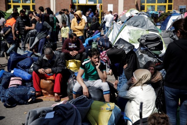 Refugiados e inmigrantes, sentados entre sus pertenencias antes de abordar un autobús hacia otras partes del país donde serán acomodados, en el Puerto del Pireo, cerca de Atenas, en Grecia, March 31, 2016. Foto: REUTERS/Alkis Konstantinidis