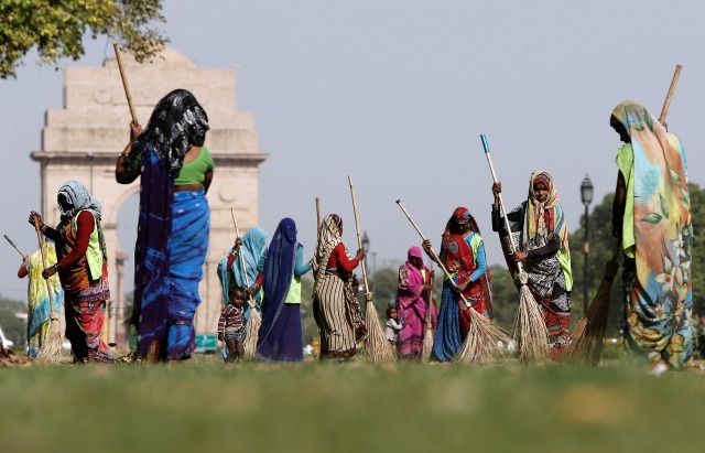 Los trabajadores municipales barren los jardines frontales de memorial de guerra Puerta de la India en Nueva Delhi, India, 13 de abril de 2016. REUTERS / Anindito Mukherjee