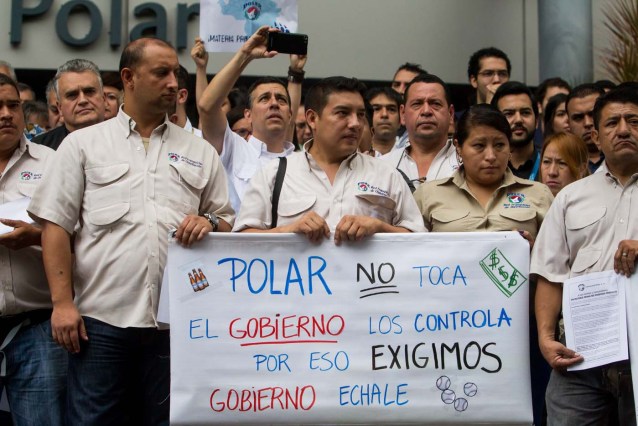 CAR23. CARACAS (VENEZUELA) 22/04/2016.- Trabajadores de empresas Polar participan en una manifestación en las inmediaciones de su edificio hoy, viernes 22 de abril del 2016, en la ciudad de Caracas (Venezuela). Los trabajadores del consorcio Polar, la principal compañía de alimentos de Venezuela, demandaron hoy al Gobierno que liquide divisas para honrar los compromisos con proveedores e importar materiales para poder continuar con sus operaciones en el país. EFE/MIGUEL GUTIÉRREZ