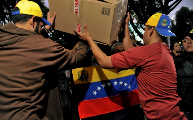 People arrange medical supplies and diapers donated during a campaign led by Lilian Tintori (not in frame), wife of Venezuela's jailed opposition leader Leopoldo Lopez, in Bogota, Colombia, on May 19, 2016. Hundreds of people, mostly Venezuelans, donate medicines and supplies to send to their country, affected by a severe shortage of products. / AFP PHOTO / GUILLERMO LEGARIA