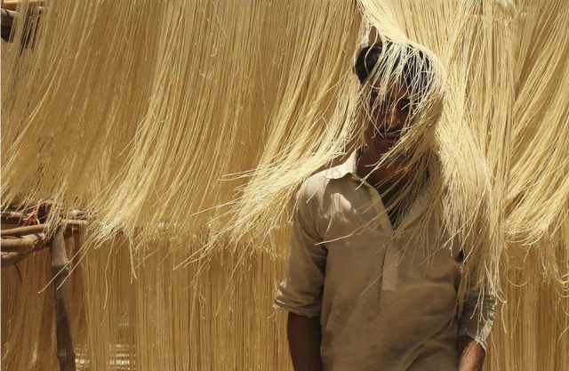 Un trabajador paquistaní pasa a través de fideos vermicellis, utilizados para postres durante el mes de Ramadán, en una fábrica en Hyderabad, Pakistán, hoy 7 de junio de 2016. Musulmanes de todo el mundo celebran el mes sagrado del Ramadán, noveno mes del calendario islámico. EFE/NADEEM KHAWER 